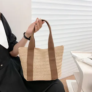 Handmade straw tote bag with brown fabric handles for summer beach vacations