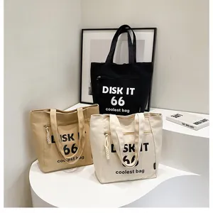 Detailed close-up of three canvas tote bags in black, khaki, and cream on a minimal display