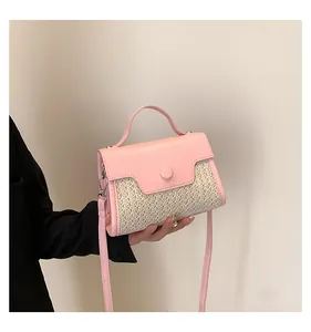 Detailaufnahme der rosa Leder- und Strohstruktur dieser eleganten Sommerhandtasche
