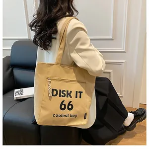 Close-up of yellow canvas tote bag with black DISK IT 66 graphics and drawstring zipper pocket