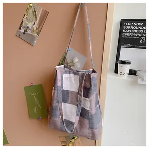 Detail of color-block canvas tote bag hanging on a cork board in a cozy studio setting