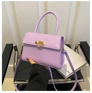 Purple small square bag with gold geometric clasp and metal chain detail