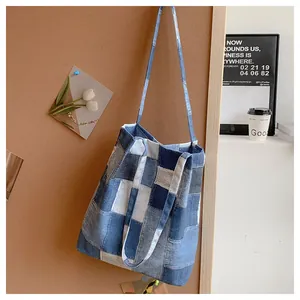 Detail of vintage patchwork denim tote bag showing blue fabric textures and wide straps