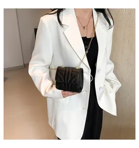 Close-up of black quilted leather crossbody bag with elegant gold chain strap detail