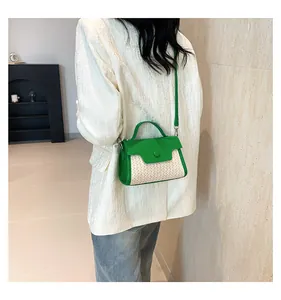 Detail der grün-beigen Stroh-Patchwork-Handtasche getragen zu einem weißen Struktur-Blazer