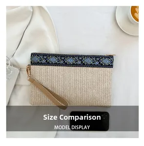 Comparaison de taille d'une pochette tissée beige avec motifs ethniques et smartphone
