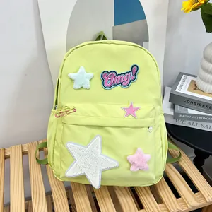 Detail view of bright green water-resistant nylon backpack with star and Omg! patches