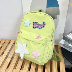 Detail view of lime green nylon backpack featuring star patches and Omg! embroidery
