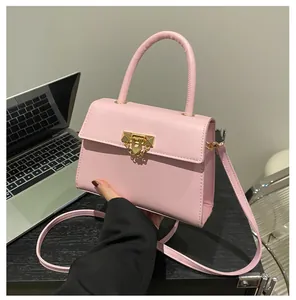 Close-up of pink leather handbag with gold metal lock and fine stitching details