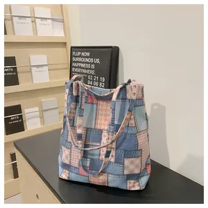 Close-up of patchwork canvas tote bag featuring denim, floral patterns and magnetic clasp