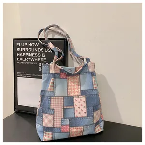 Detail of canvas tote bag showing mixed denim print, pink plaid, and magnetic clasp closure