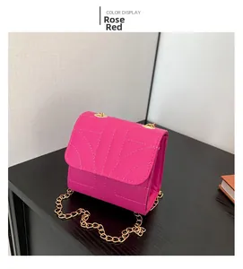 Detail of rose red flap bag with stylish quilted patterns and golden chain strap