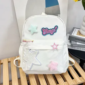 Detail of white backpack featuring colorful star patches and Omg embroidery decoration