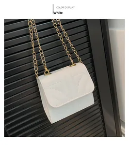 Detail of white chain crossbody bag with geometric stitching and gold metal hardware