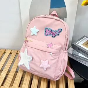 Close-up of pink school backpack featuring plush stars and an embroidered Omg! badge