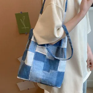 Blue denim patchwork tote bag with frayed edges and long shoulder strap for women