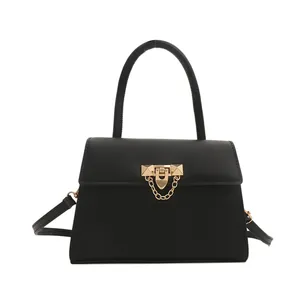 Minimalist black leather handbag with gold metal clasp and top handle for women