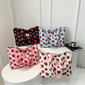 Fashionable strawberry print canvas tote bags in four colors on display stands
