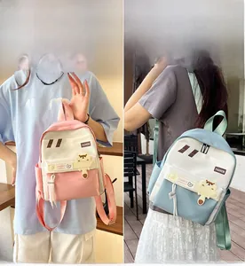 Dettagli degli zaini leggeri rosa e blu per studenti con graziosi ciondoli a forma di orso