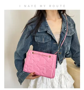 Détail du sac rose avec gaufrage en étoile et bandoulière en chaîne dorée tressée