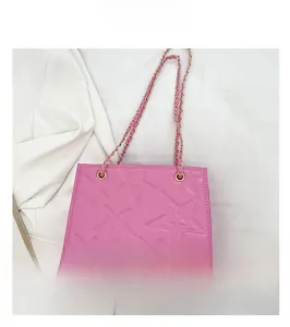Détail du sac bandoulière rose avec texture étoile embossée et bandoulière chaîne dorée