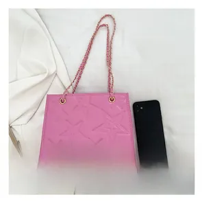 Sac à bandoulière rose avec motif étoile et chaîne dorée à côté d'un téléphone
