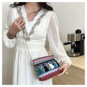 Close-up of ethnic woven crossbody bag with colorful patterns and tassel charms