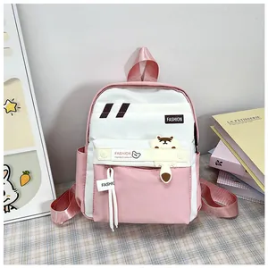 Dettaglio ravvicinato dello zaino rosa e bianco con toppe di animali e logo FASHION