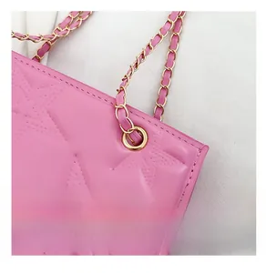 Détail du sac en cuir rose avec surpiqûres étoiles et bandoulière chaîne dorée