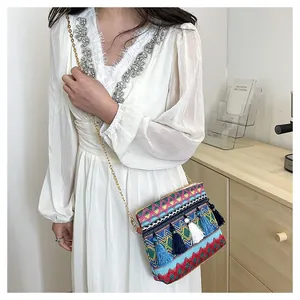 Detail showing colorful geometric weave and three-tone tassel charms on bohemian crossbody bag