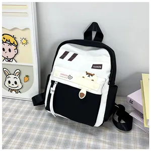 Dettaglio dello zaino scolastico minimalista bianco e nero con toppa carina