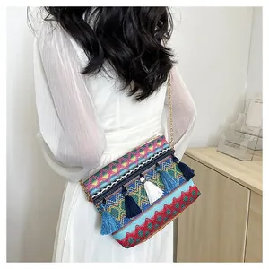 Detailed shot of bohemian woven bag featuring colorful geometric patterns and blue fringe
