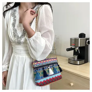 Detail of bohemian woven bag with colorful geometric embroidery and tiered fringe tassels