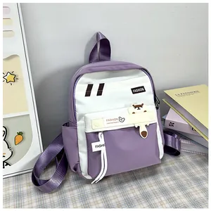 Dettaglio dello zaino scolastico viola e bianco con patch cartoon e cinturino