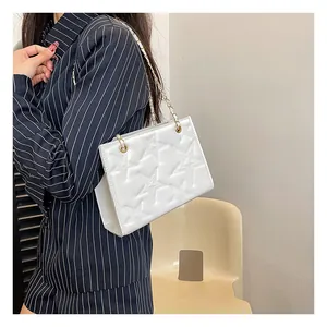 Détail du sac bandoulière blanc avec texture étoile embossée et bandoulière chaîne dorée