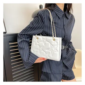 Détail du sac blanc rectangulaire avec surpiqûres étoiles et chaîne dorée