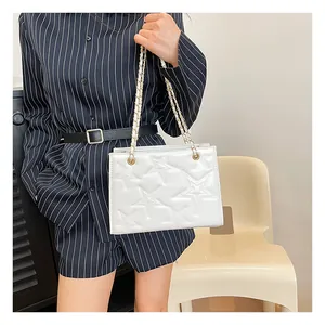Détail du sac à bandoulière blanc avec motif d'étoiles en relief et bandoulière chaîne