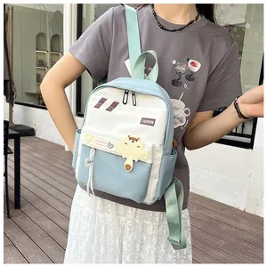 Dettaglio dello zaino in nylon leggero con pannelli blu e ciondolo a forma di orso