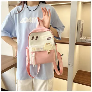 Dettaglio dello zaino rosa e bianco con toppa a cartone animato e spallacci regolabili