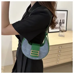 Detalle del bolso de hombro de retales en cuero verde y lana gris con hebilla dorada