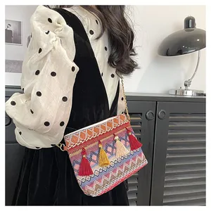 Close-up of Bohemian woven crossbody bag with colorful tassels and gold chain strap