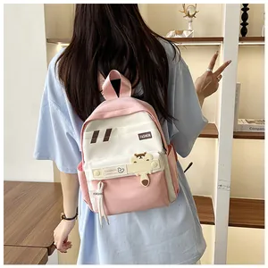 Dettaglio dello zaino in tela rosa e beige con ciondolo a orso e spallacci alla moda