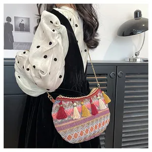 Λεπτομέρεια boho υφασμένης τσάντας χιαστί με πολύχρωμα κρόσσια και χρυσή αλυσίδα