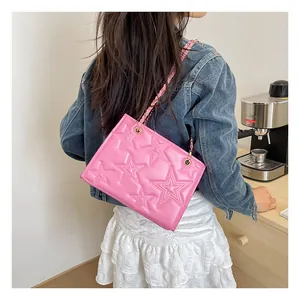 Sac bandoulière rose avec étoiles gaufrées et bandoulière chaîne dans un café