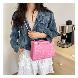 Sac bandoulière rose avec étoiles gaufrées et chaîne dorée porté par mannequin
