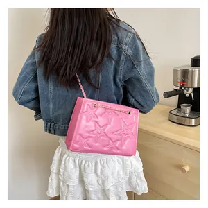 Photo de mode d'un sac à bandoulière rose brodé d'étoiles avec chaîne sur modèle