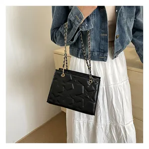 Détail du sac bandoulière noir avec surpiqûres étoiles et chaîne dorée chic