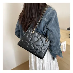 Détail du sac bandoulière noir avec motif étoile en relief et chaîne dorée