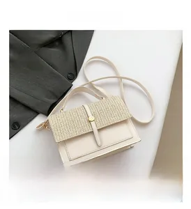 Detail view of woven flap texture and golden button on a cream faux leather handbag