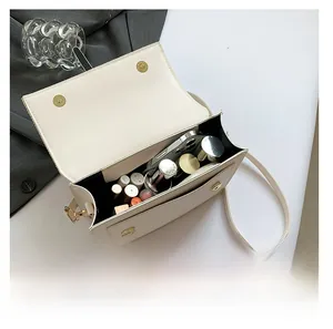 Interior view of the cream crossbody bag showing capacity for phone and cosmetics